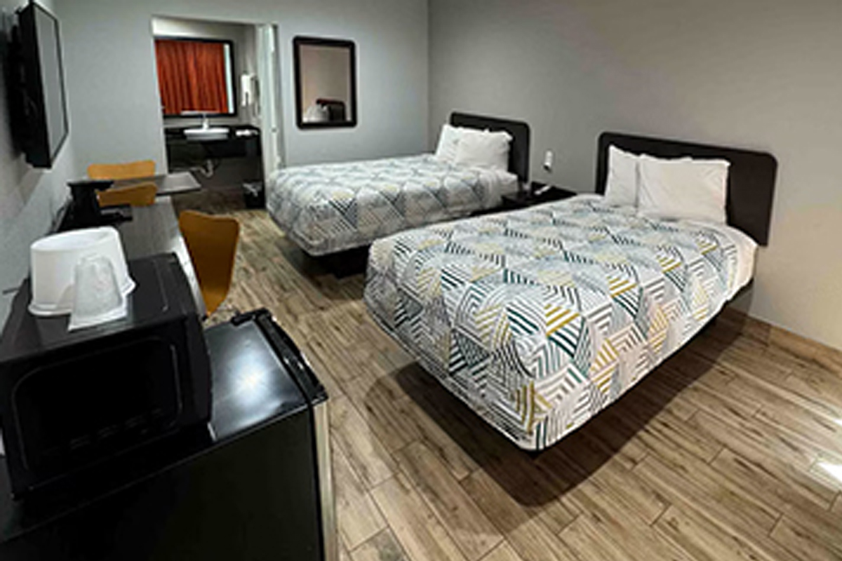Guest room with two beds, television and micro-fridge